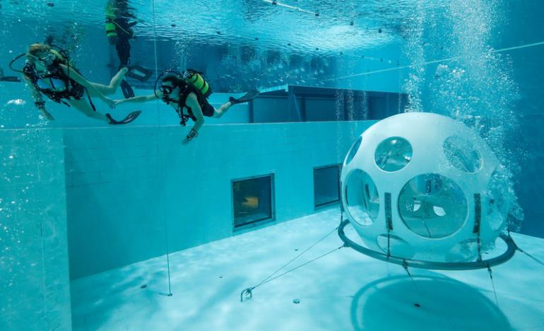 Belgians Florence Lutje Spelberg and Nicolas Mouchart dive next to “The Pearl”, a spheric dining room placed 5 metres underwater in the NEMO33 diving center in Brussels