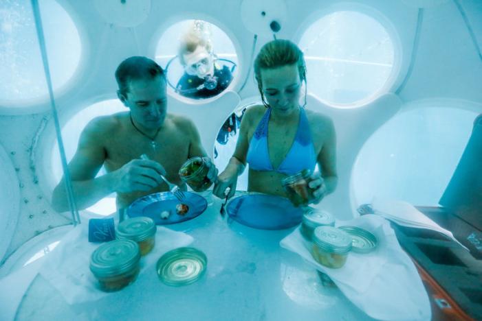 Belgians Florence Lutje Spelberg and Nicolas Mouchart have dinner while sitting inside “The Pearl”, a spheric dining room placed 5 metres underwater in the NEMO33 diving center in Brussels