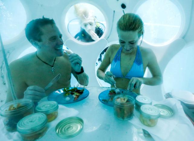 Belgians Florence Lutje Spelberg and Nicolas Mouchart have dinner while sitting inside “The Pearl”, a spheric dining room placed 5 metres underwater in the NEMO33 diving center in Brussels